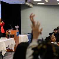 Girls of Color Summit previous event a speaker pointing at a participant raising her hand